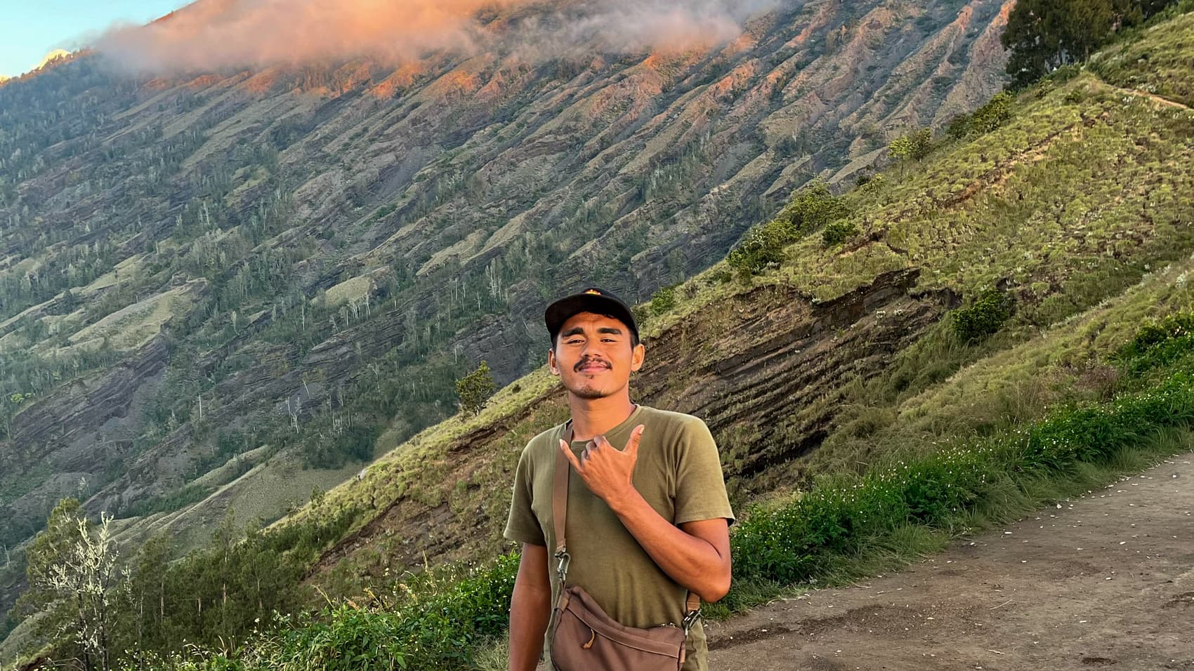 Zainal, lead guide, on the trail with the Rinjani summit catching first light behind him