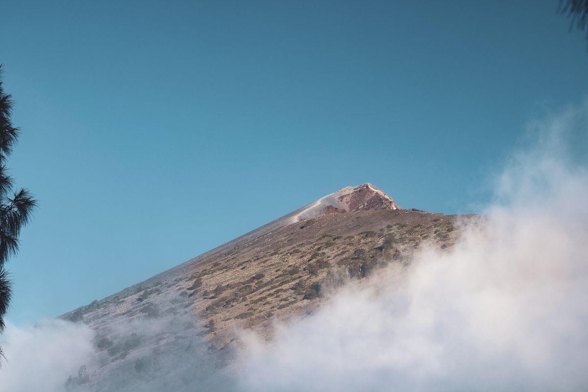 The peak of Rinjani rising above a bank of cloud
